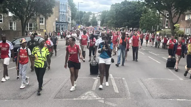 Groups of Arsenal fans spill down Beresford Road, near Canonbury Station.