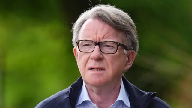 An older man in glasses and a quarter-zip pullover against an out-of-focus green background.
