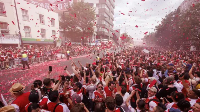 A huge crowd with red confetti in the air