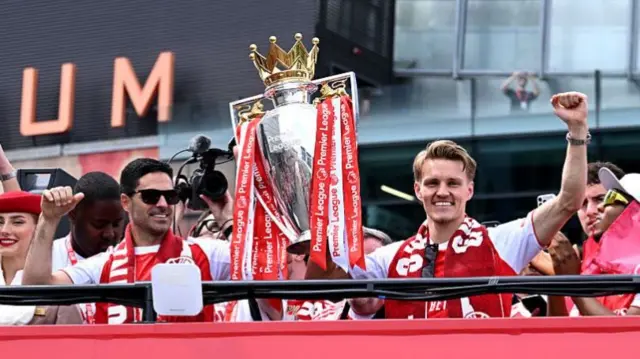 Mikel Arteta, Arsenal manager, and Martin Odegaard of Arsenal celebrate with the Premier League trophy