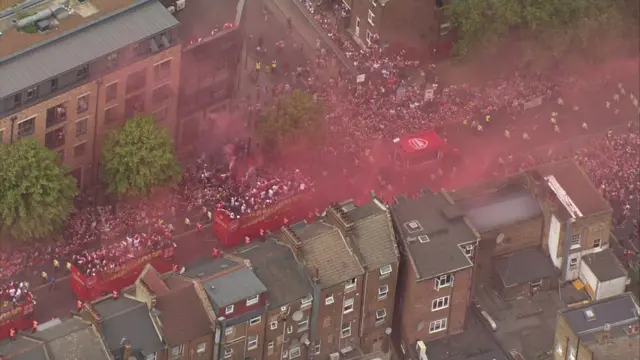 The buses as seen from the air - red smoke fills the air