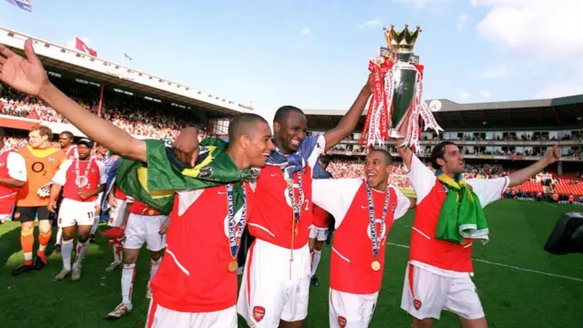 Gilberto, Patrick Vieira, Gael Clichy and Edu of Arsenal with the Premier League trophy after the match between Arsenal and Leicester City in the Premier League at Highbury on May 15, 2004