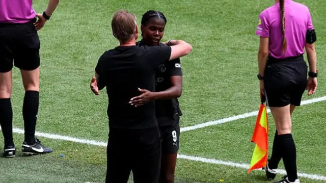 Andree Jeglertz, Manager of Manchester City, embraces Khadija Shaw as she leaves the field