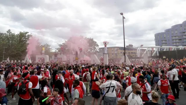 A crowd of Arsenal supporters in front of Emirates Stadium