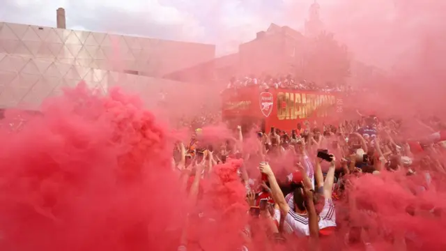 Red smoke fills the area as fans celebrate