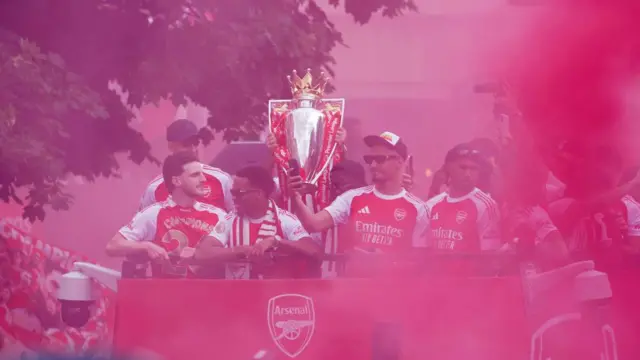The players on the bus with the trophy
