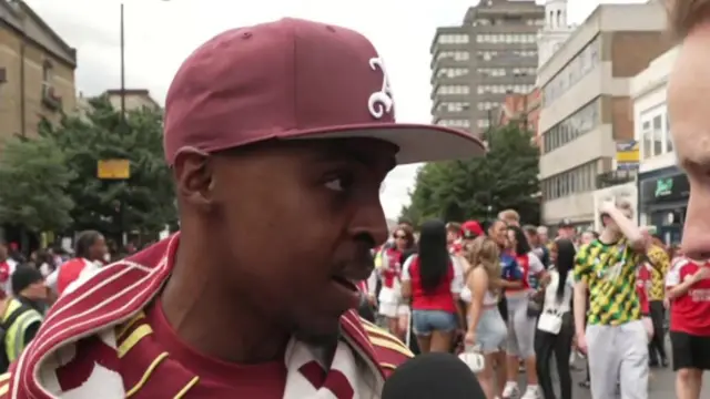 A fan speaks to a BBC reporter from the parade