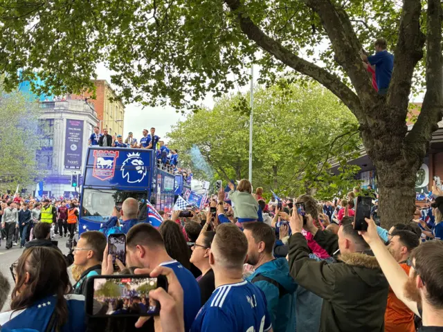 Crowds of people gather with their phones to catch a glimpse at the Ipswich Town bus