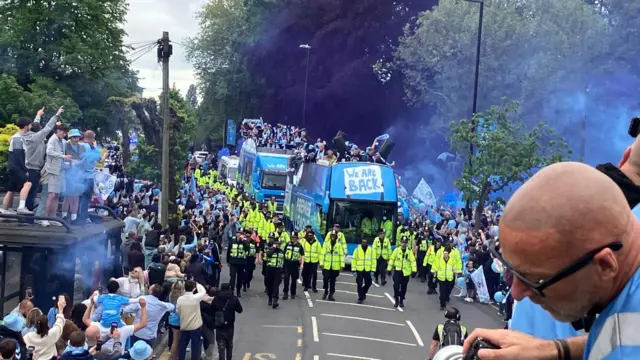 Police surround the buses as they move through the streets