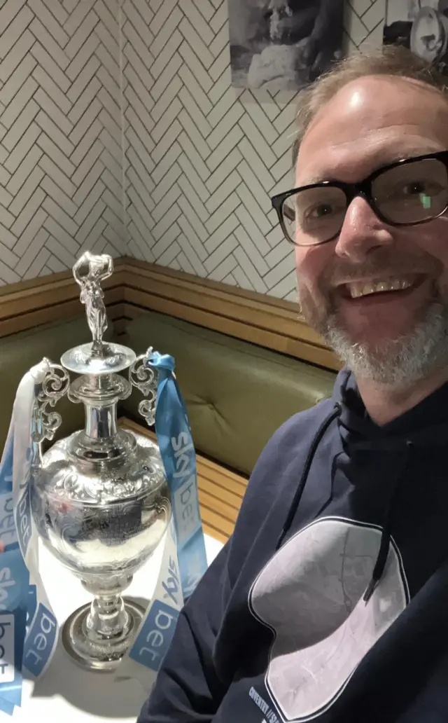 Man poses with championship trophy
