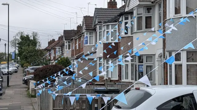 Sky blue bunting on a series of terraced homes