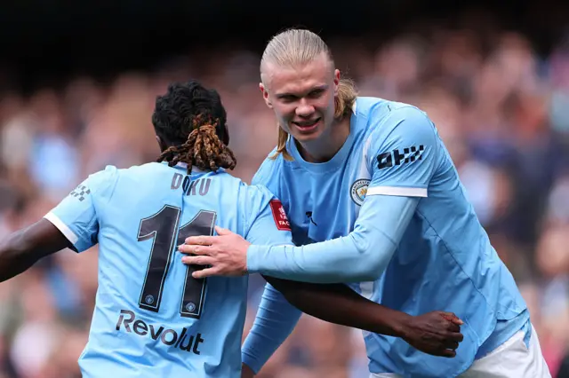 Erling Haaland and Jeremy Doku hug