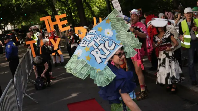 Wendy Brandes, wearing a “Eat the Rich” headdress, walks the "Resistance Red Carpet" in protest of the Met Gala