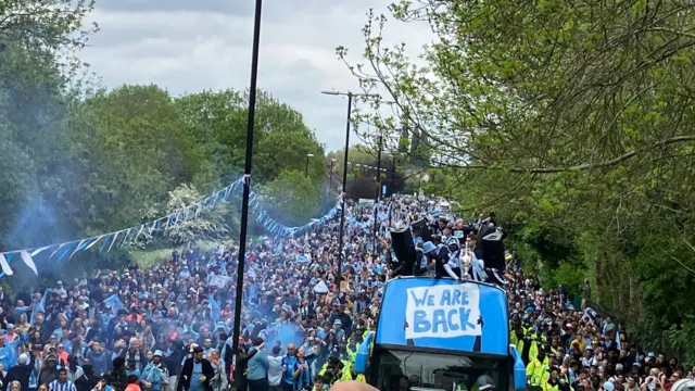 Two sides of the road are awash with fans as the bus pushes through