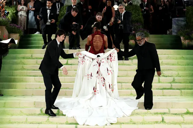 Osaka's team removes her flowing white coat to reveal a different dress underneath