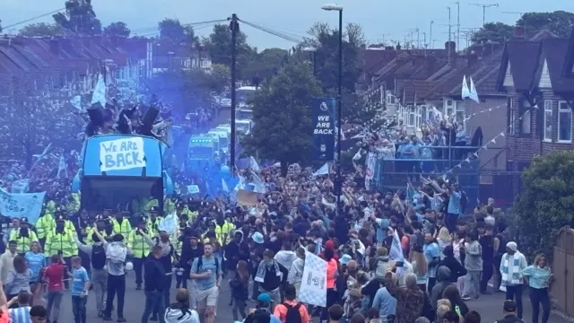 The bus passes hundreds of fans