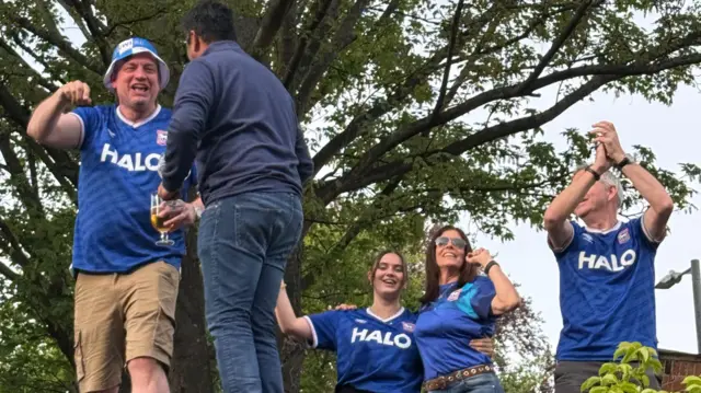 Fans standing on a rooftop in Ipswich shirts