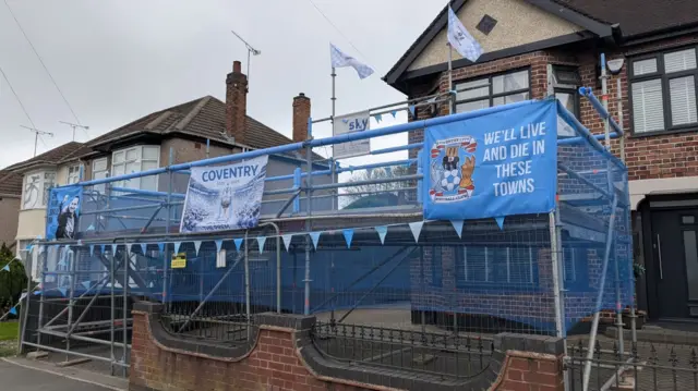 Scaffolding with Sky Blues posters on them