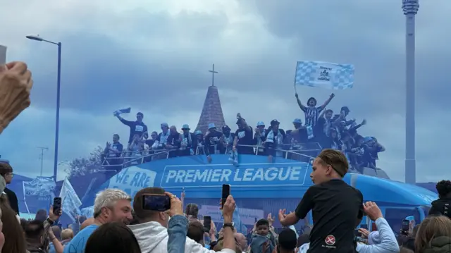 Fans celebrating as the bus goes past