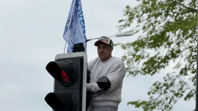 A man on a traffic light with a Coventry flag