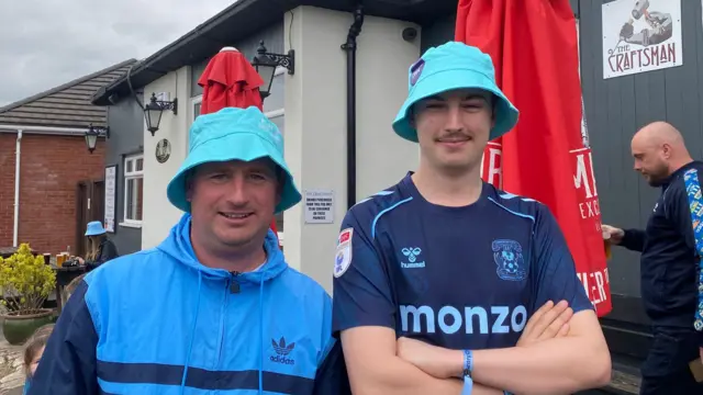 Two men in bucket hats outside a pub