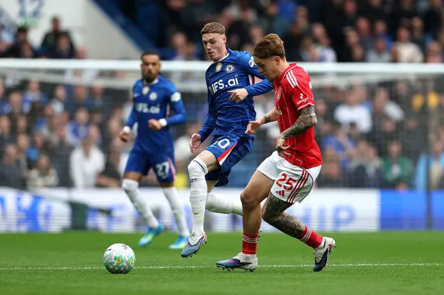 Cole Palmer of Chelsea and Luca Netz of Nottingham Forest battle for possession