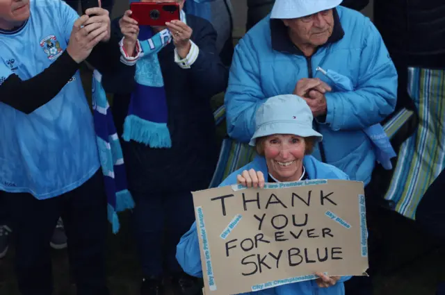 A woman holds a sign