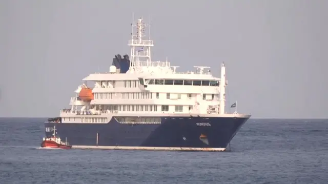 MV Hondius at sea with a smaller boat next to it