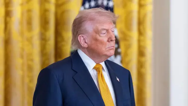 Trump listens as First Lady Melania Trump delivers remarks during a Military Mother's Day Event