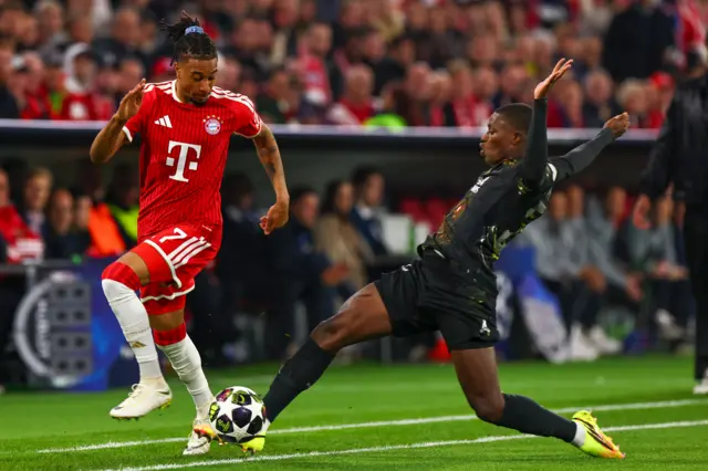 Michael Olise of Bayern Munich (L) in action against Nuno Mendes of PSG