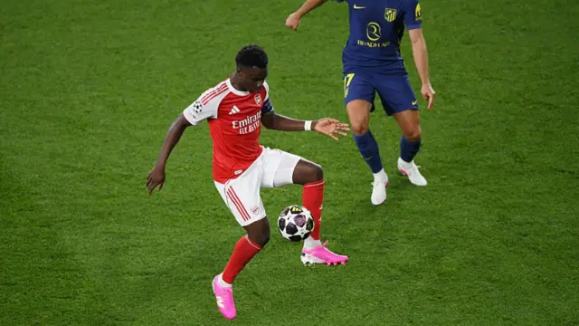 Bukayo Saka of Arsenal controls the ball while under pressure from David Hancko