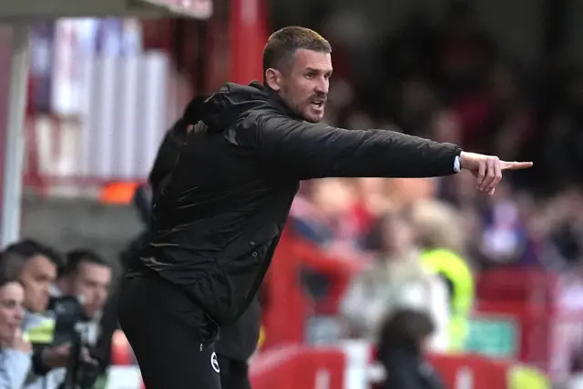 Vidosic shouts and points instructions from the sideline