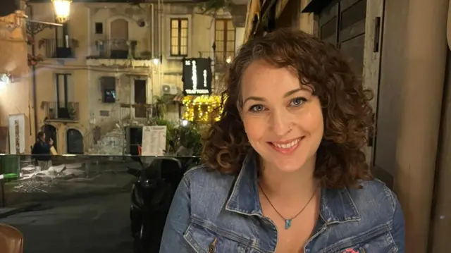A headshot of Megan Clarke wearing a denim jacket and looking at the camera