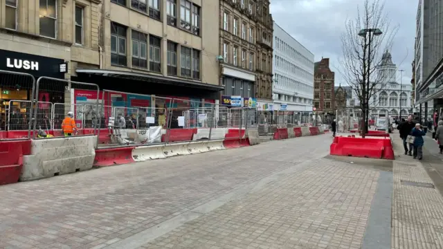 Pinstone Street in Sheffield City Centre is bordered by construction and temporary fencing.