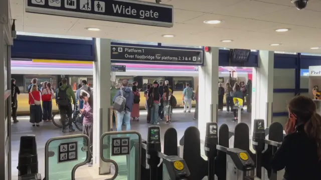 Passengers standing in front of the barriers at Southampton train station following delays and cancellations