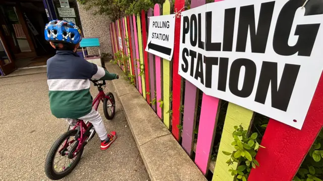 Young boy on bike at polling station in Inverness