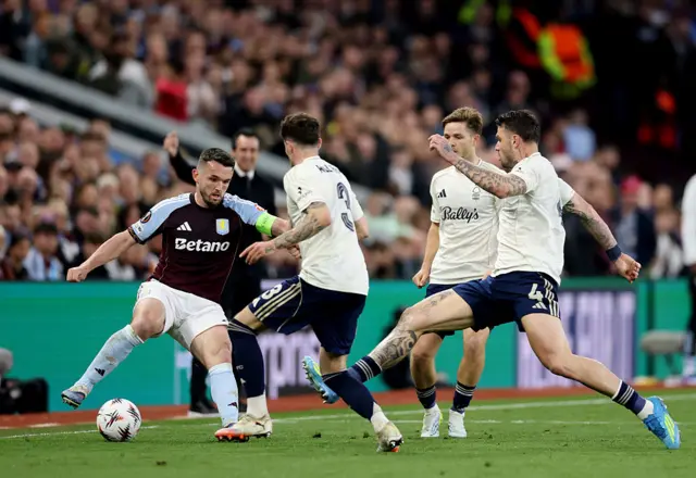 McGinn is closed down by several Forest players