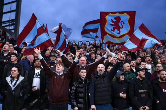 Aston Villa fans cheer and wave flags