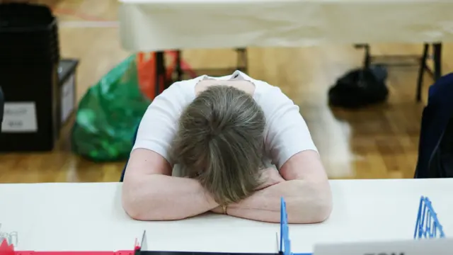 A woman sleeps as she waits for ballot papers to arrive during the Middlesbrough and East Cleveland Count on May 8, 2015 in Redcar, England