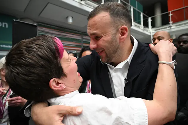 Zoe Garbett and Zack Polanski embrace at an election count.