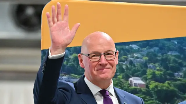 John Swinney waves