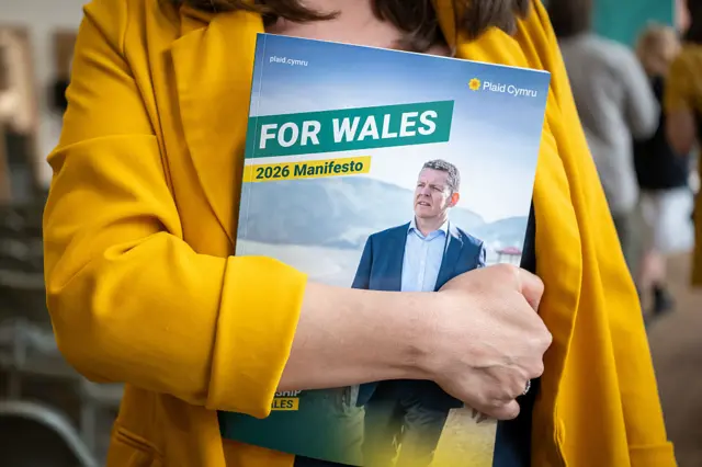 Someone holding a Plaid Cymru manifesto