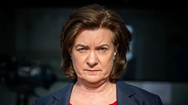 First Minister of Wales Eluned Morgan, she has brown hair and is wearing a navy suit and a red top