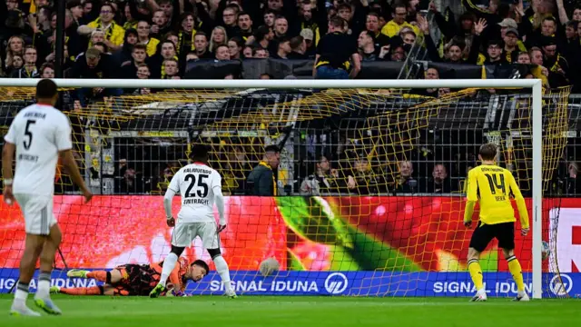 Dortmund's Swiss goalkeeper 01 Gregor Kobel dives but fails to stop the opening goal