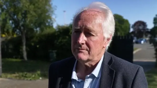 Elderly man in suit giving interview in a park