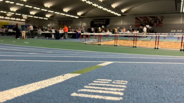 A view of a sandpit in a leaisure centre shot from across a running track