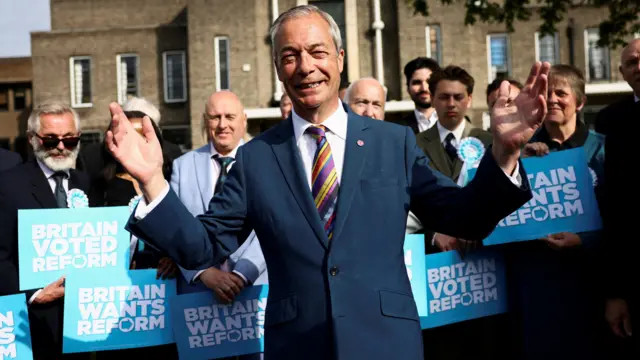 Nigel Farage holds his arms wide, with Reform supporters behind him
