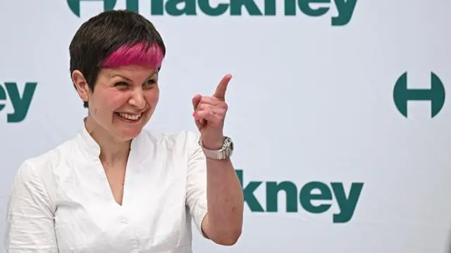 Zoe Garbett gestures while making a speech on stage