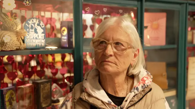 Jackie stands in front of a shop