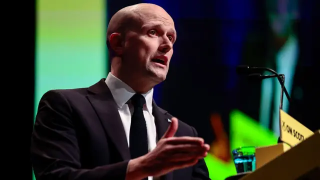 Stephen Flynn speaks at a lectern during an SNP conference in March